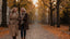 Two friends in autumn coats walking on a leafy street
