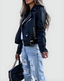 Biker jacket styled with ripped jeans