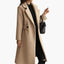 Camel belted coat worn open with a bag