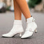 White heeled ankle boots worn with white socks
