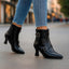 Black heeled ankle boots worn with jeans