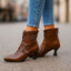 Women's Double Buckle Pointed Toe Heeled Boots in brown, styled with light denim