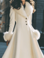 Close view of the faux fur shawl collar on the ivory coat