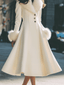 Side view showing the flared hem of the ivory winter coat
