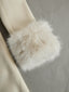 Detail of the faux fur cuff on the ivory coat