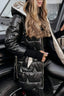 Black satin puffer jacket worn with a bag
