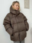 Brown oversized puffer coat shown with the collar up