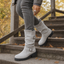 Gray slouch boots worn with jeans outdoors