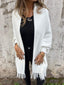 White fringed cardigan worn with black trousers