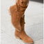 Light brown slouch boots worn on a pavement
